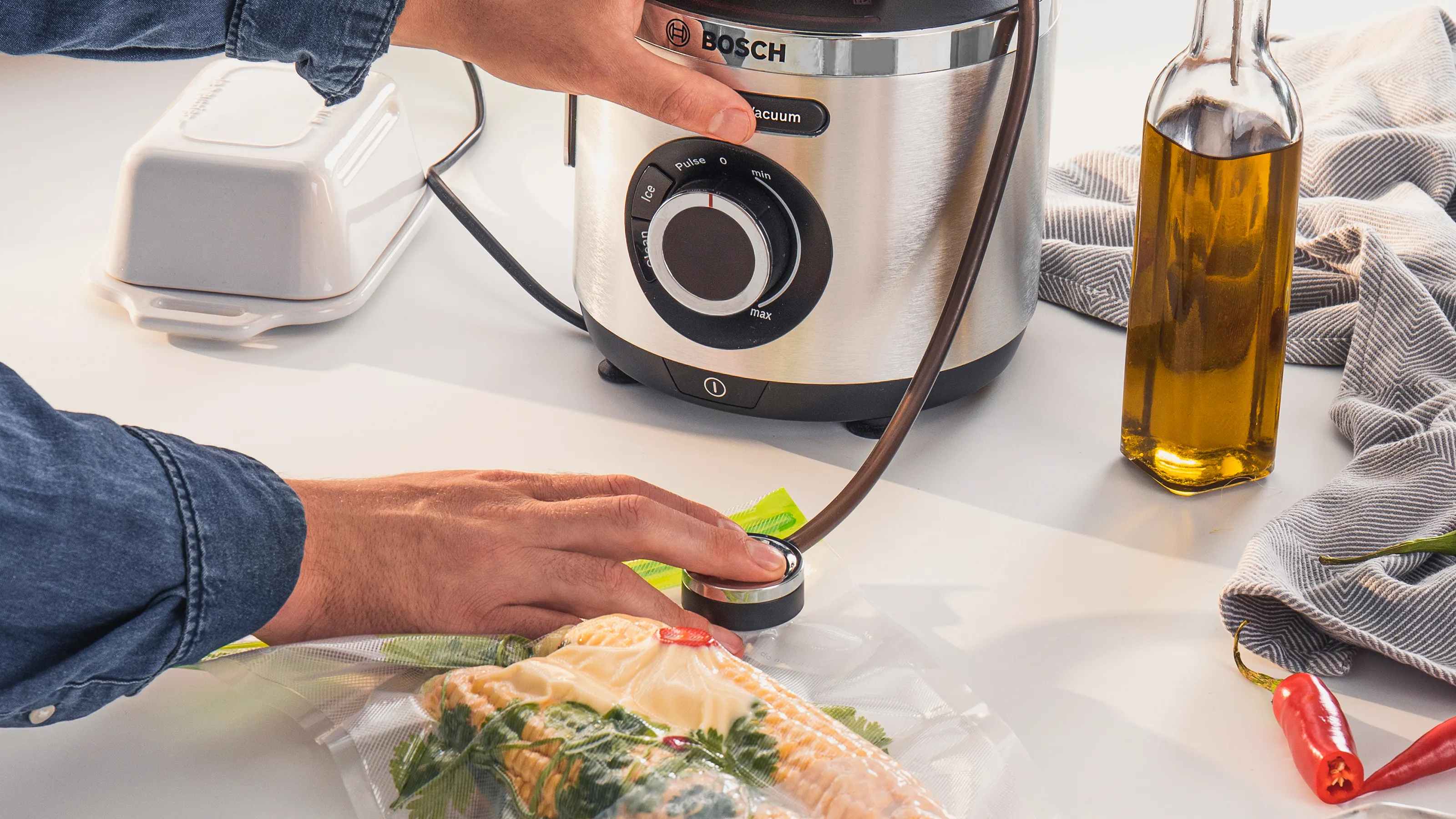 Une personne appuie sur un bouton pour aspirer l'air et conditionner sous vide les aliments.