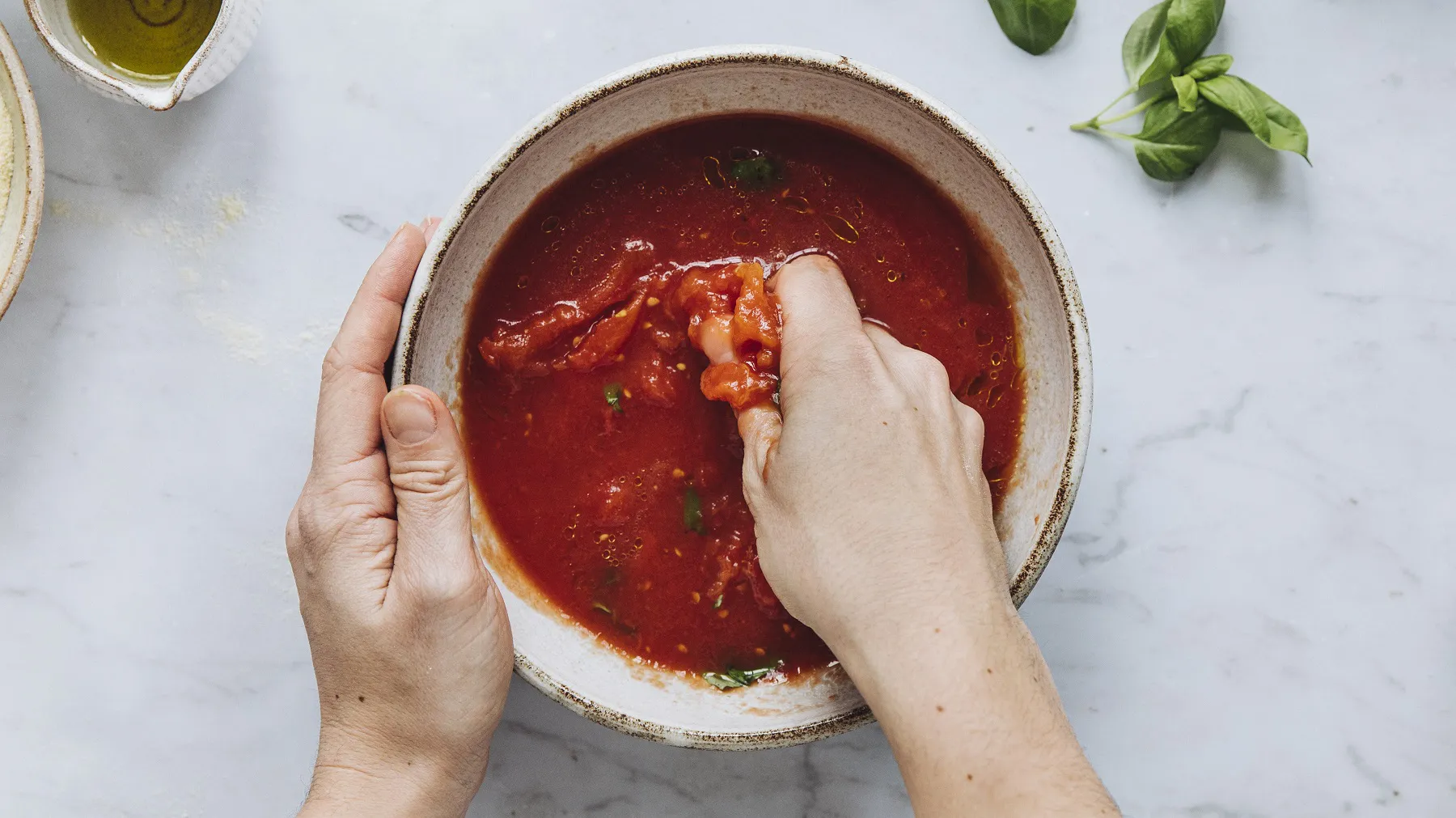 Hände rühren Tomatensauce in einer Schüssel