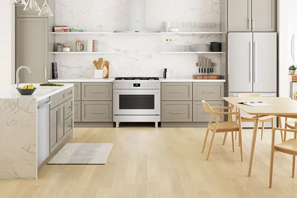 Modern kitchen with light cabinets, marble backsplash, Bosch stainless steel appliances, and wooden dining table.