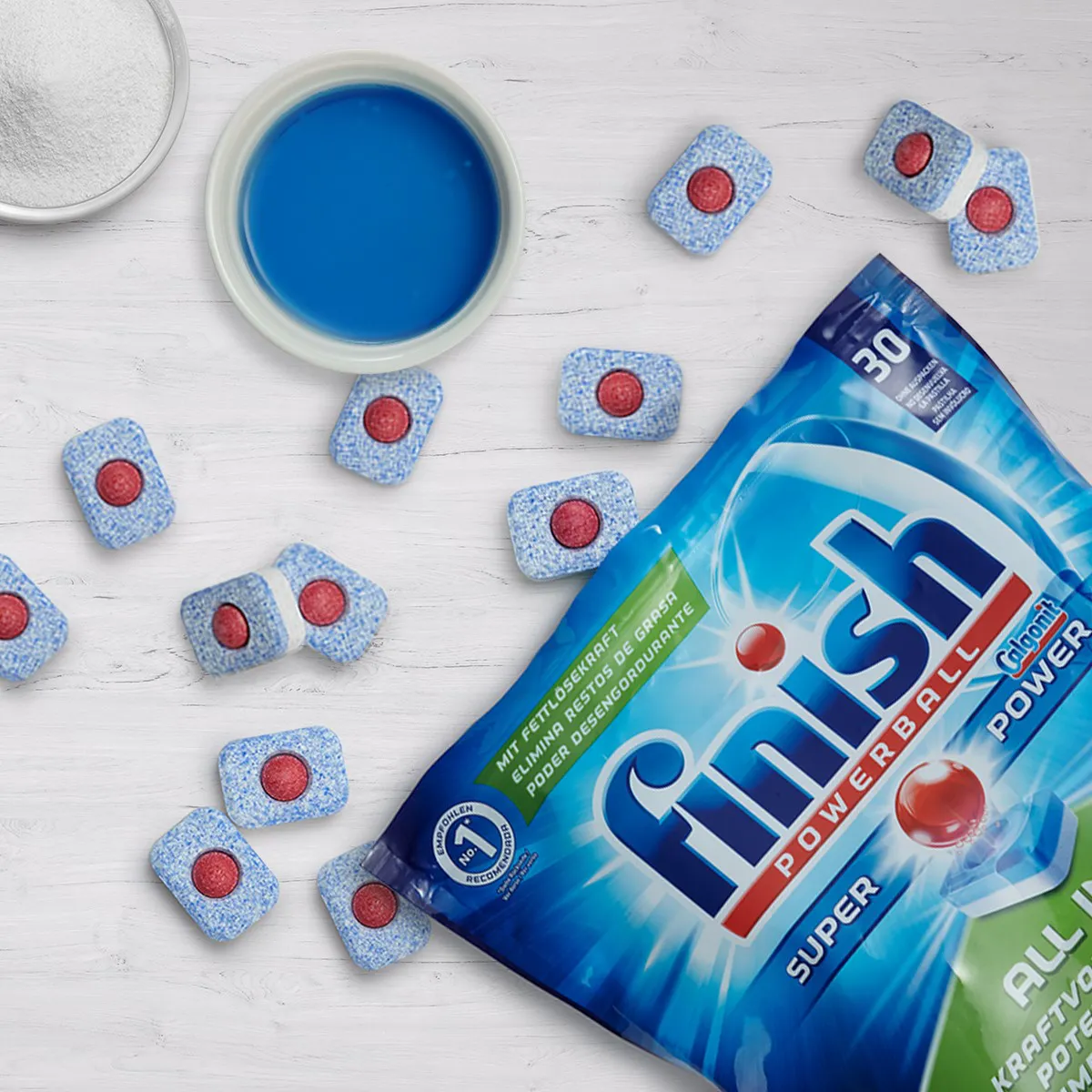 Finish Powerball dishwashing tablets and open packet on white background.