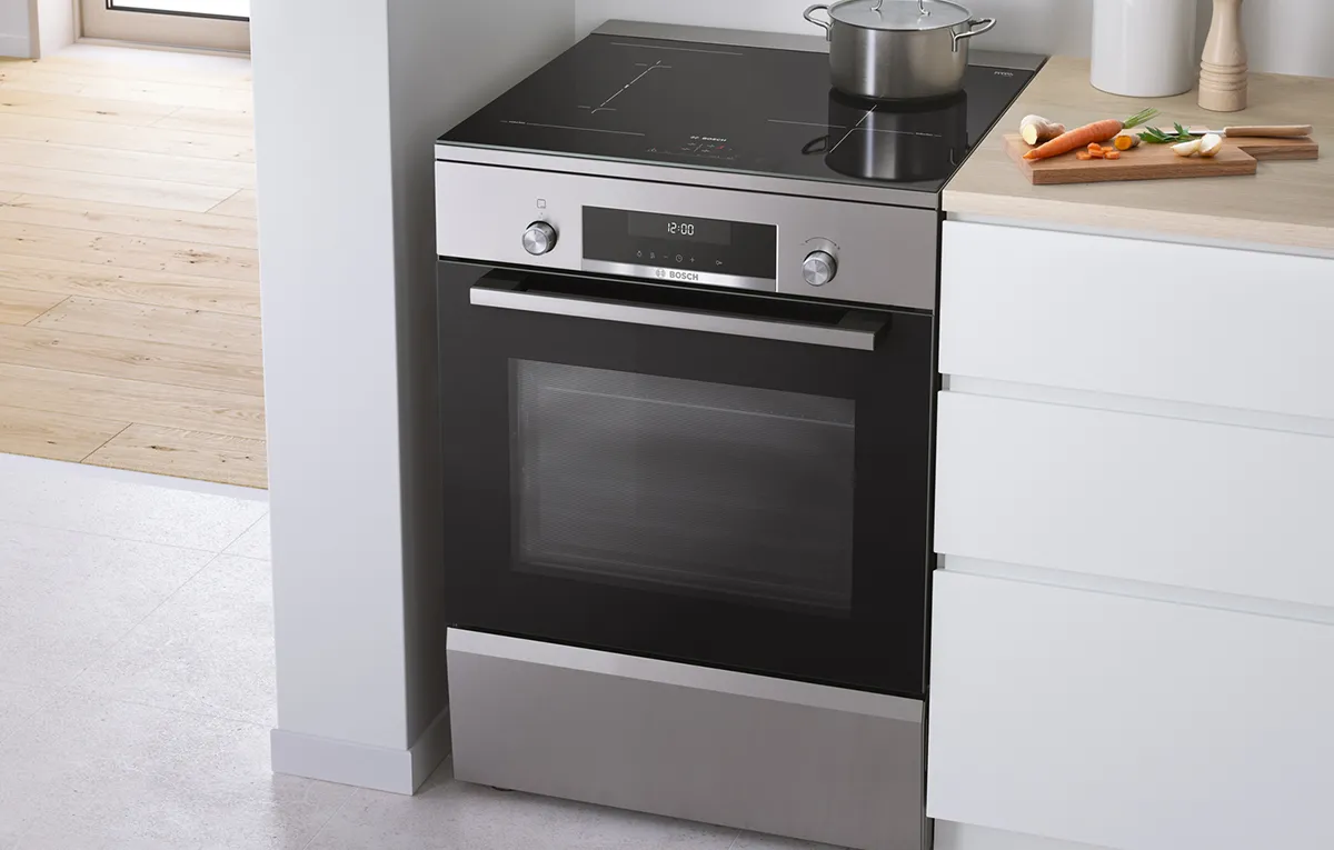 A Bosch freestanding cooker placed next to a kitchen worktop.