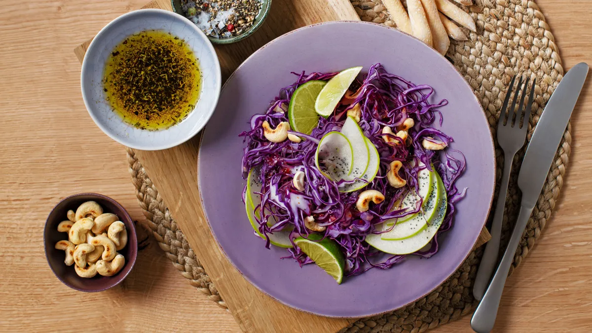 Een smakelijke salade van vers versneden groenten met cashewnoten.