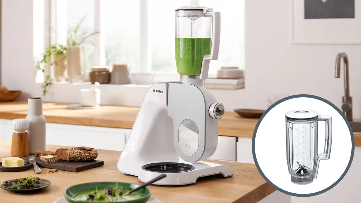 Bucătărie blat cu blender, produse alimentare, și un borcan mixer de sticlă umplut cu smoothie verde.