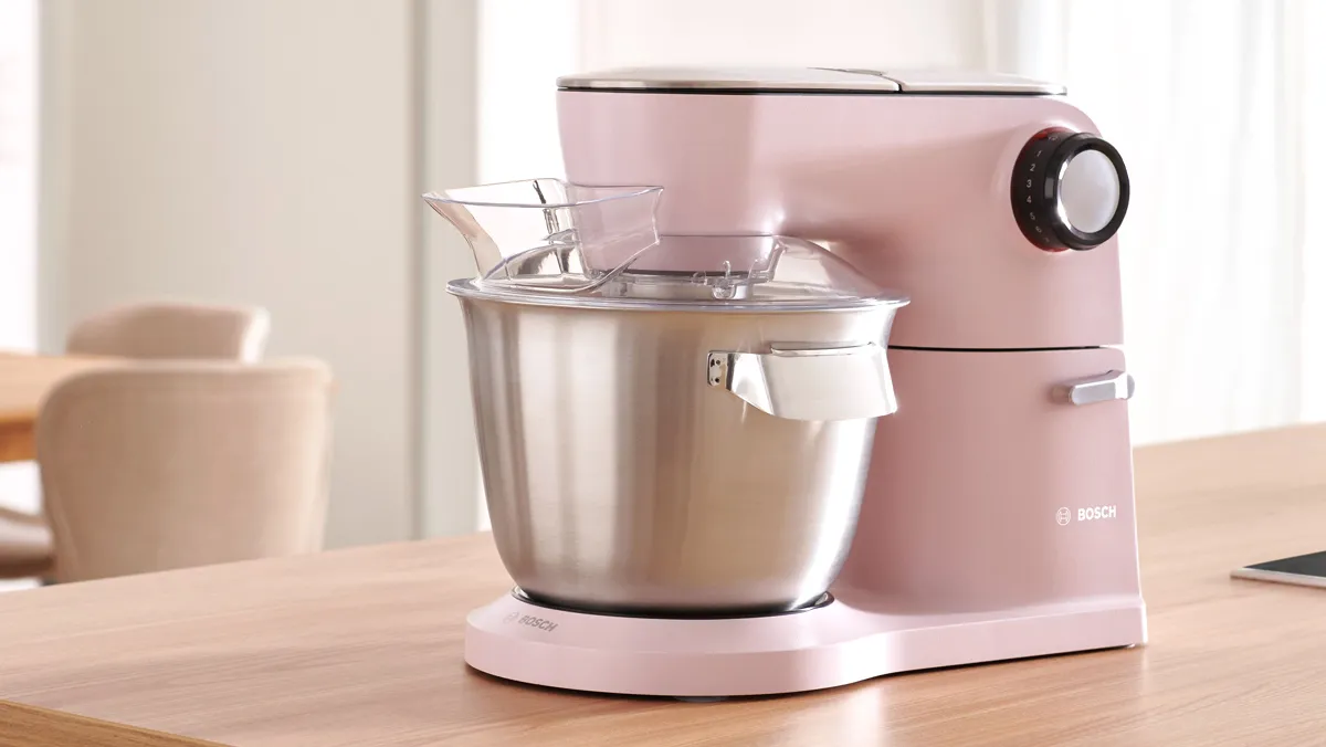 A red Bosch stand mixer on a kitchen counter. 