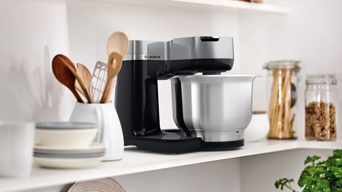 Küçük cihazlar, aletler ve baharat kavanozları ile mutfak sayacı. Minimalist, organize tasarım.