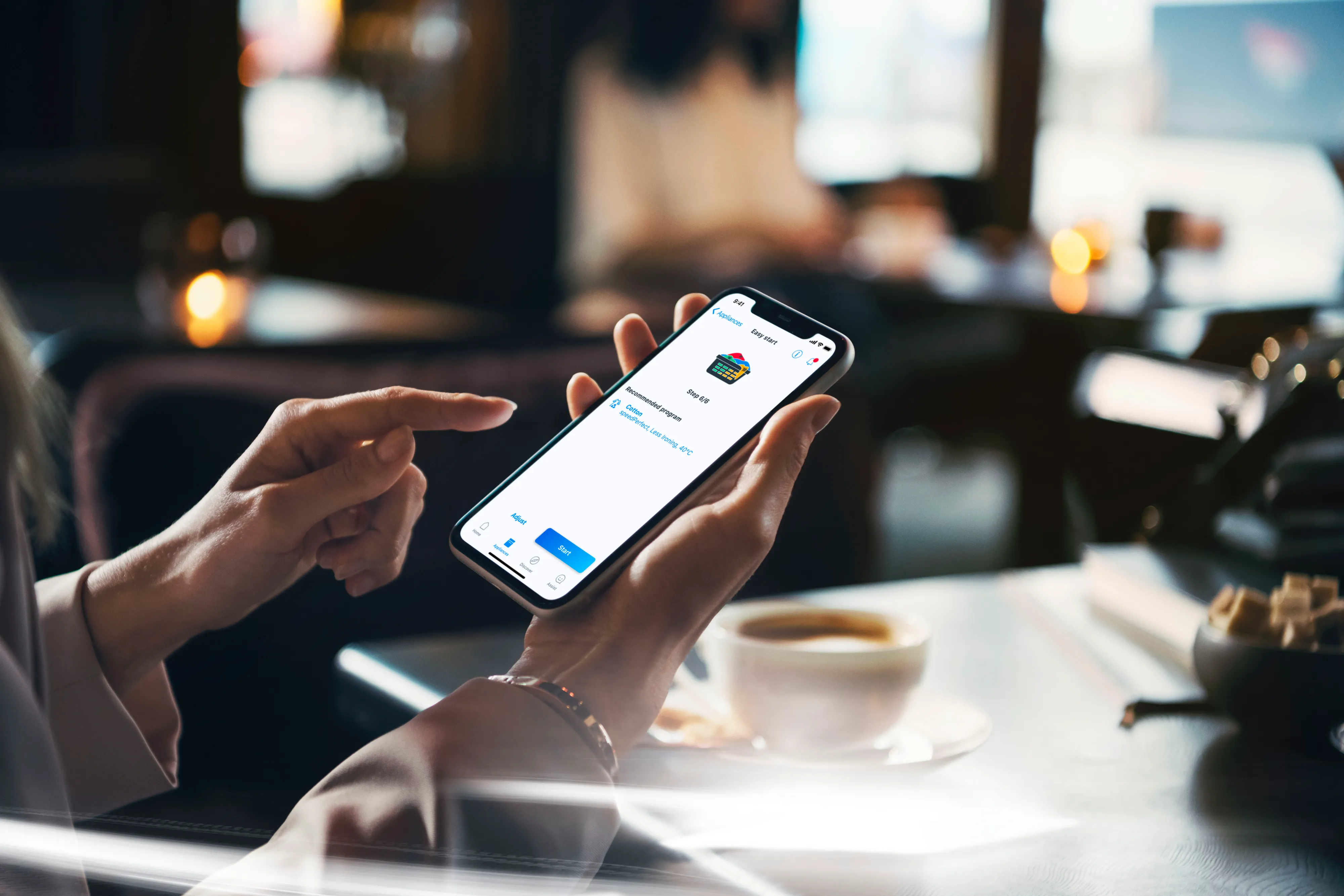 Smartphone med Home Connect app åben holdes i hånden