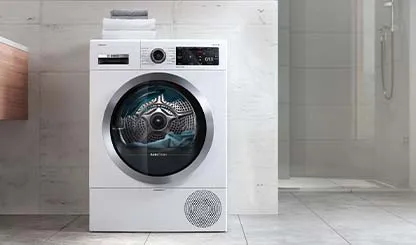 Modern banyo ayarında dijital ekran ile beyaz çamaşır makinesi.