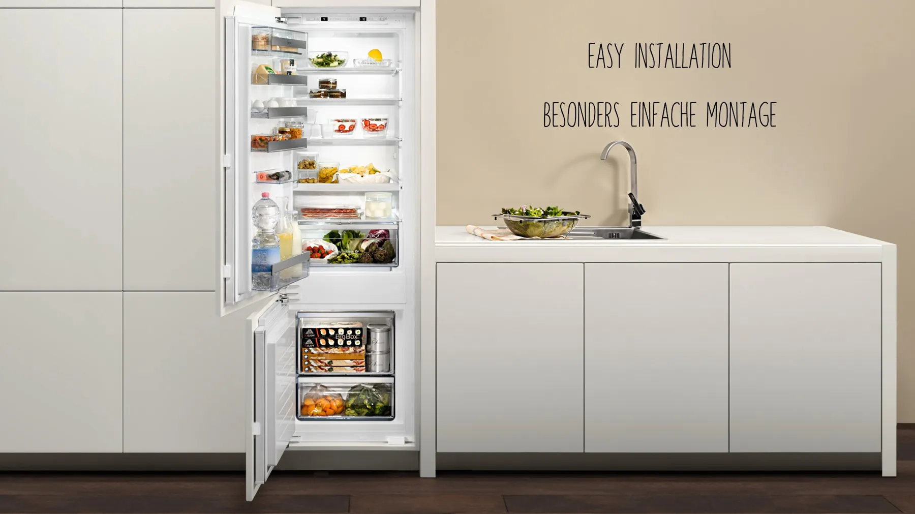 Offener Kühlschrank mit Lebensmittelartikeln, Küchentisch mit Spüle, Text "Easy Installation, einfache Montage" auf Deutsch.