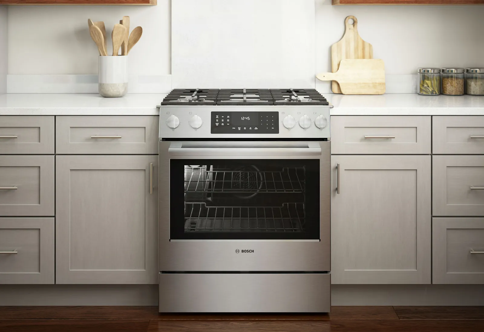 Modern Bosch stainless steel gas range with oven, set in a white kitchen with wooden accents.