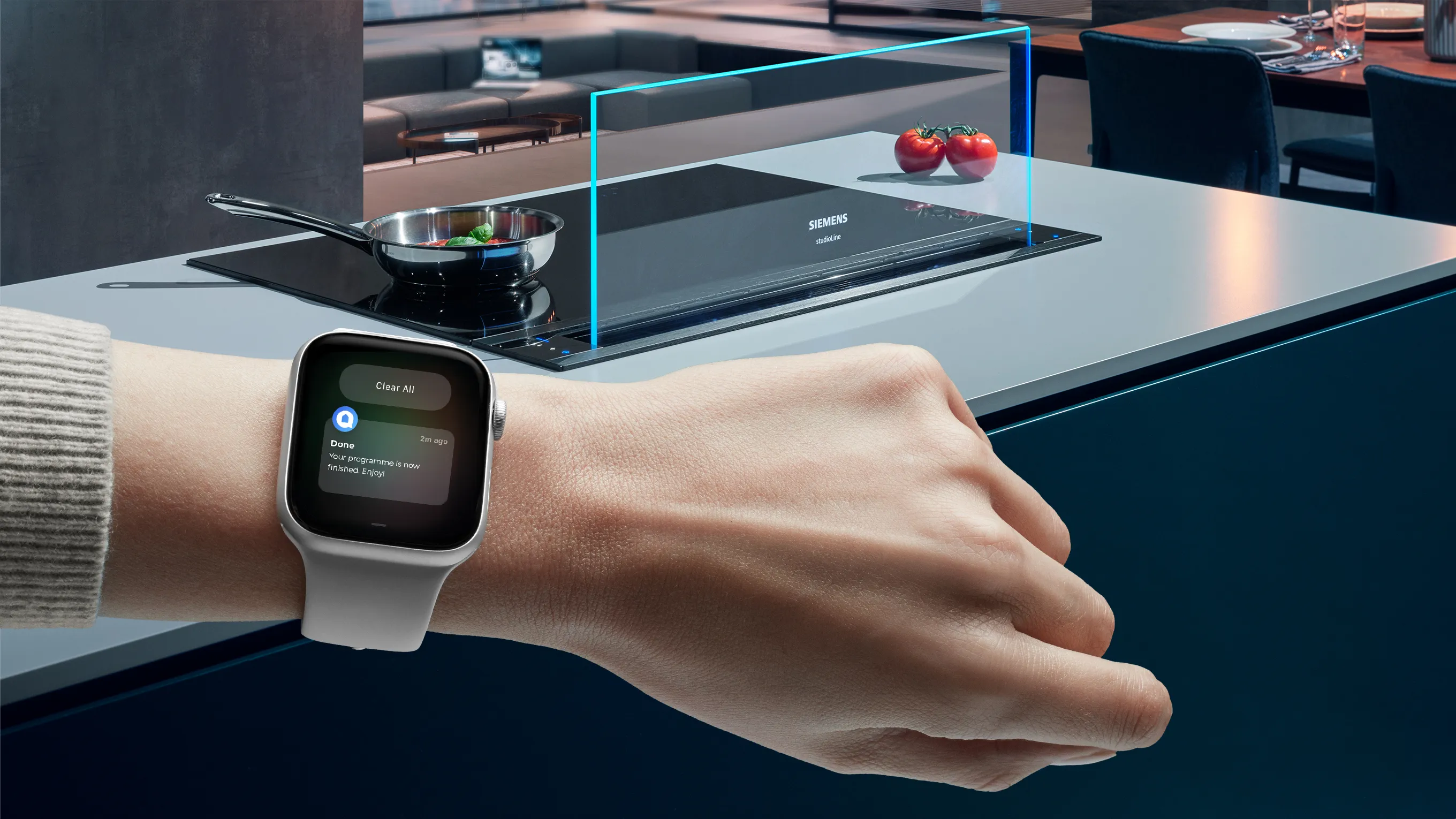 Person wearing smartwatch in kitchen with cooking appliances and utensils.