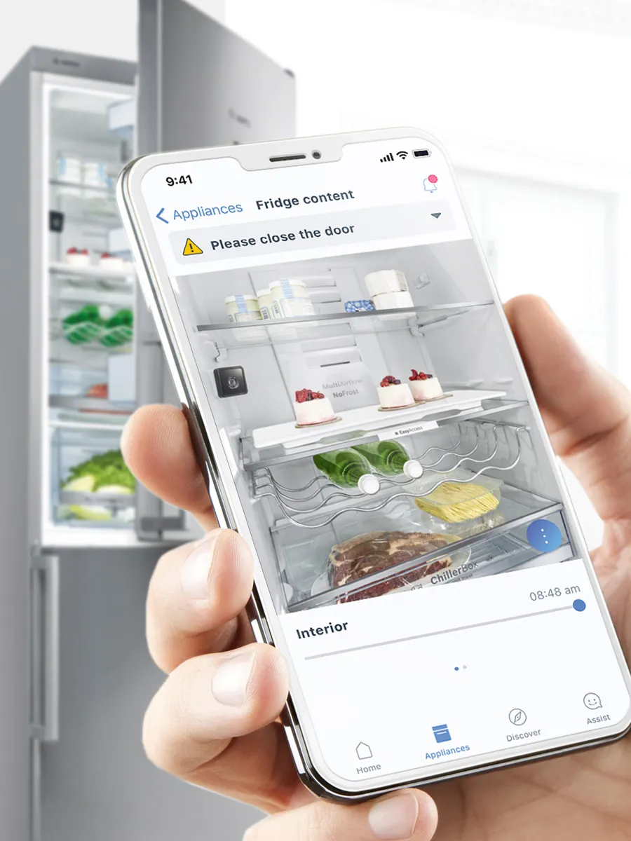 A hand holding a smartphone displaying a home appliance app, with options for controlling devices.