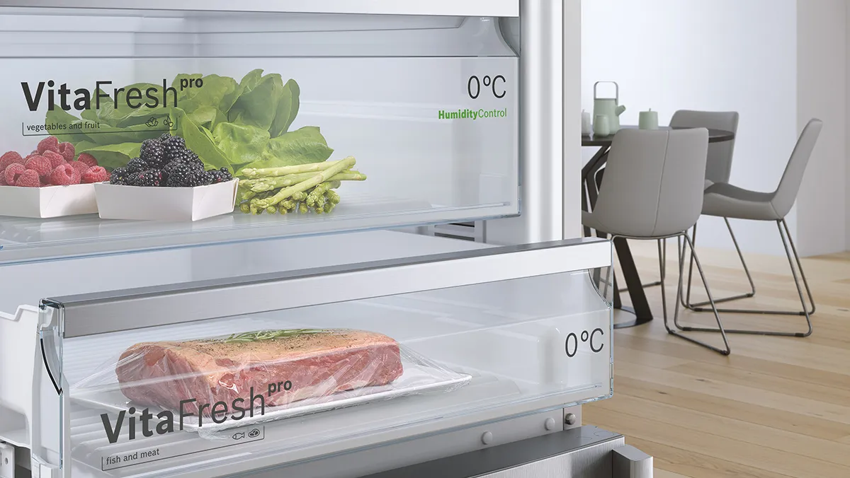 صورة مقربة للجزء الداخلي لثلاجة Bosch VitaFresh Pro، تُظهر حجرات VitaFresh التي تحتوي على المنتجات الطازجة (الخضراوات والفواكه) واللحوم، مما يشير إلى التحكم الدقيق في درجة الحرارة والرطوبة للحفاظ على الطعام بشكل مثالي.