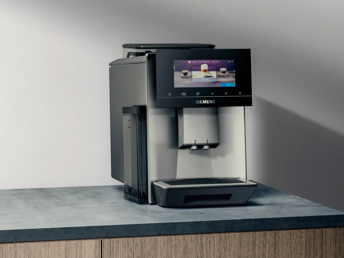 Sleek, modern coffee machine with touch screen display and milk frother on wooden countertop.
