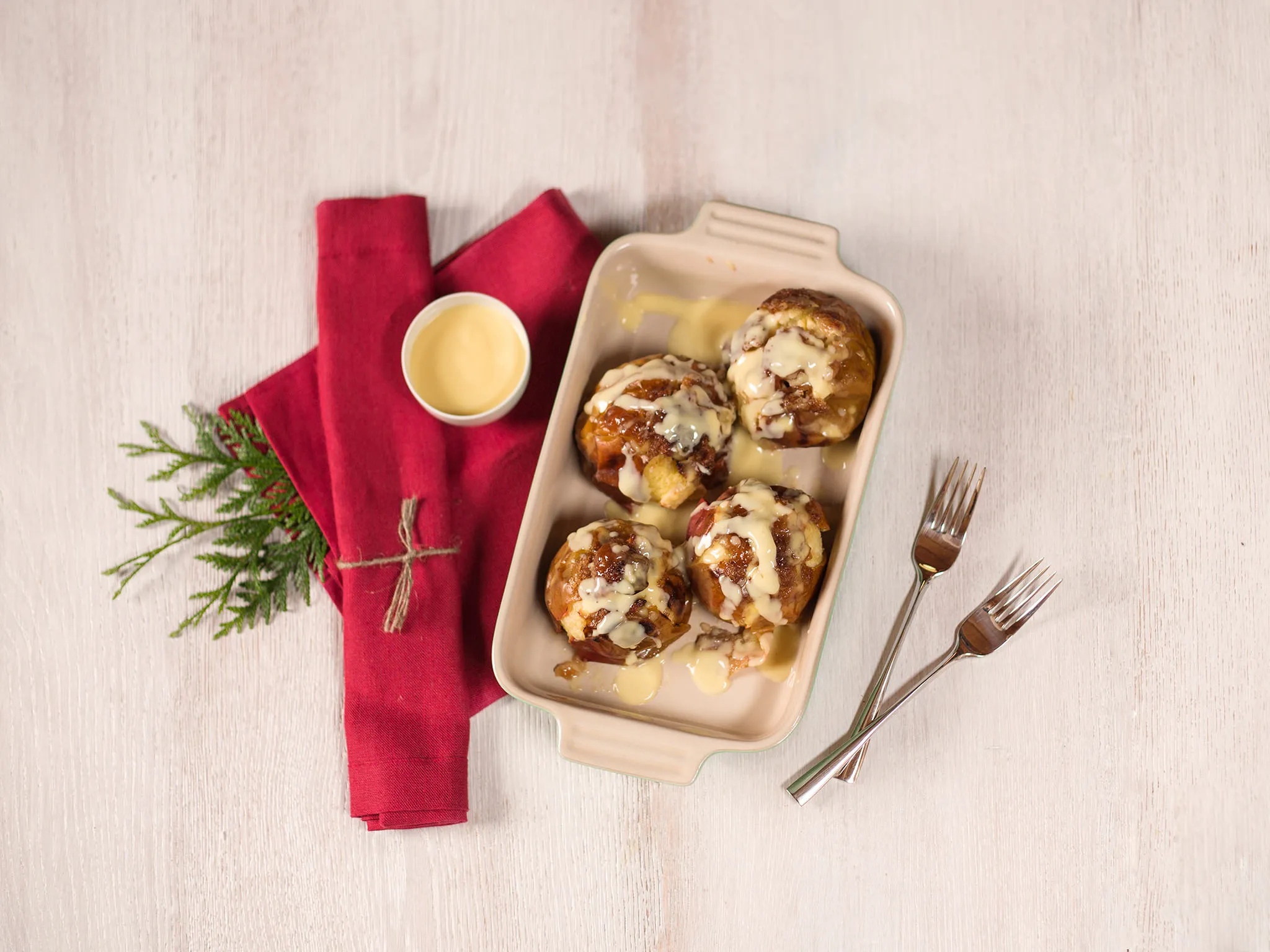 Baked pastries with fillings, served on a tray with a red napkin and a sprig of greenery.