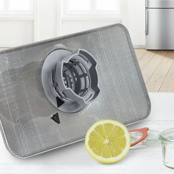 Dishwasher filter on kitchen top with lemon next to it.