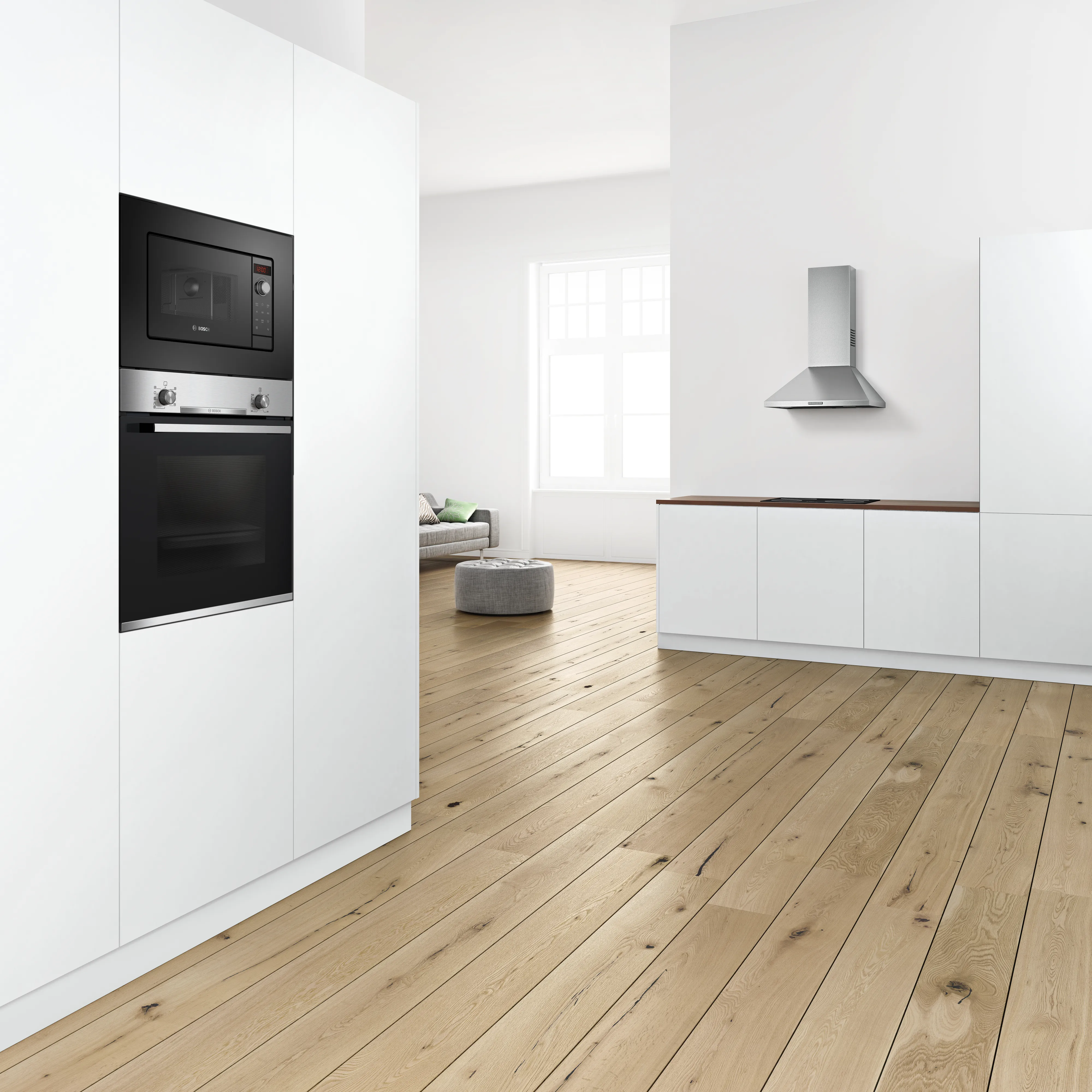 Moderne, weiße Küche mit integriertem Bosch Serie 2 Backofen und Mikrowelle sowie einer freistehenden Edelstahl-Dunstabzugshaube über der Kochzeile.