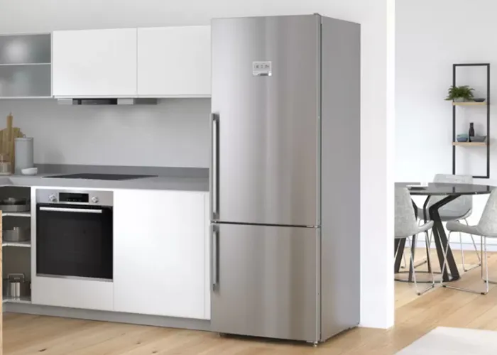 Beyaz kabinler, paslanmaz çelik buzdolabı ve yemek alanı ile modern mutfak.