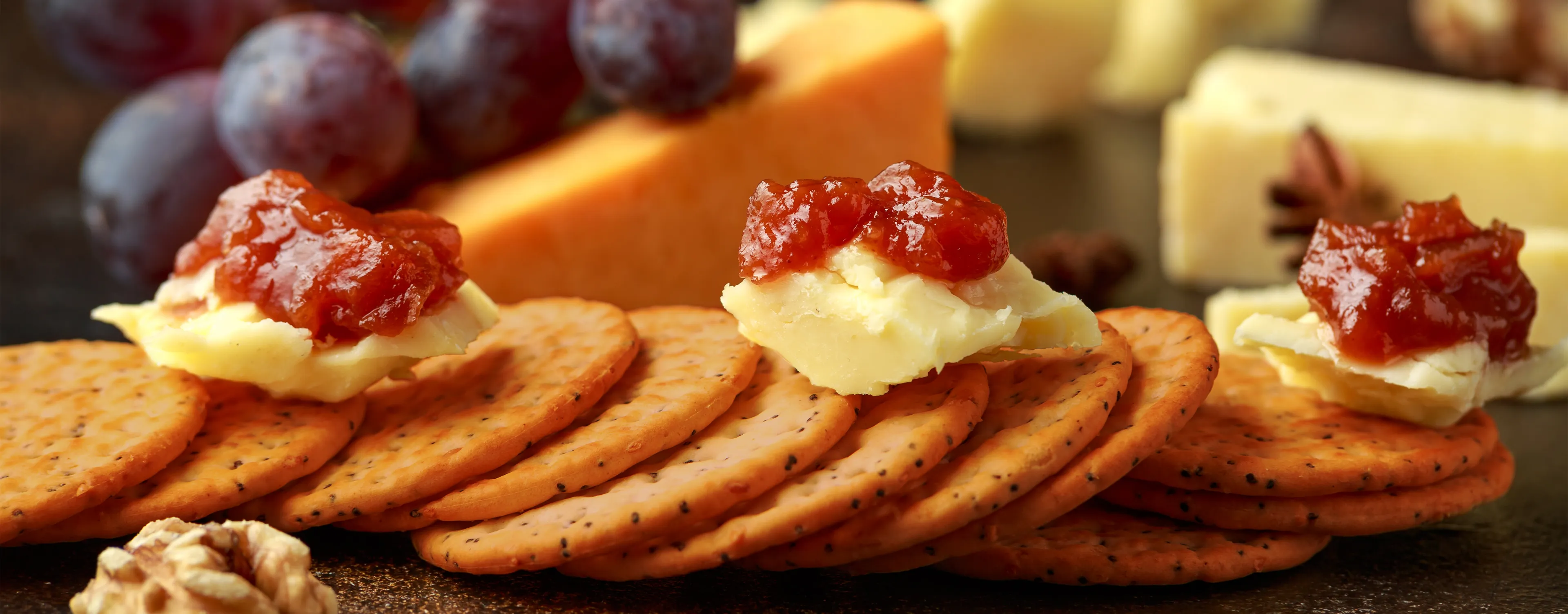 Platter of crackers grapes chutney and a mixture of cheeses