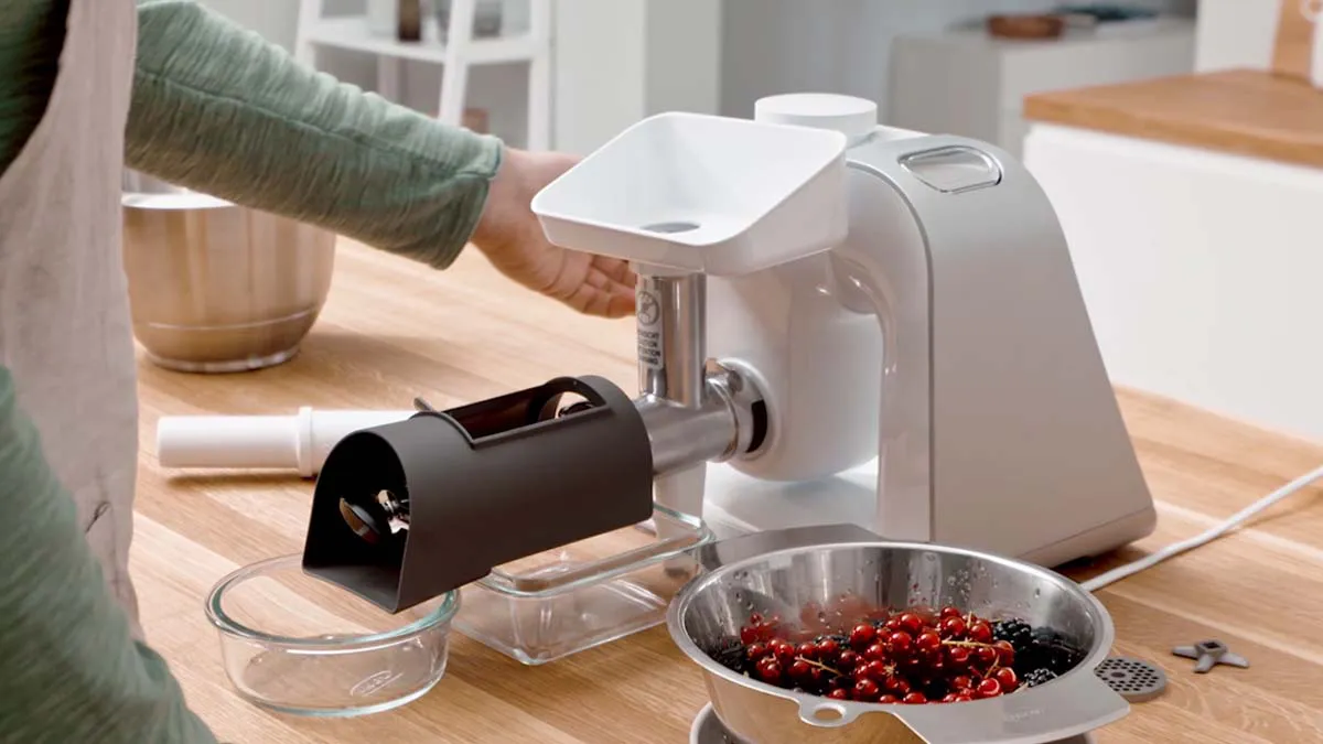 Kitchen appliance, food processor, grinding berries, wooden table, kitchen utensils.