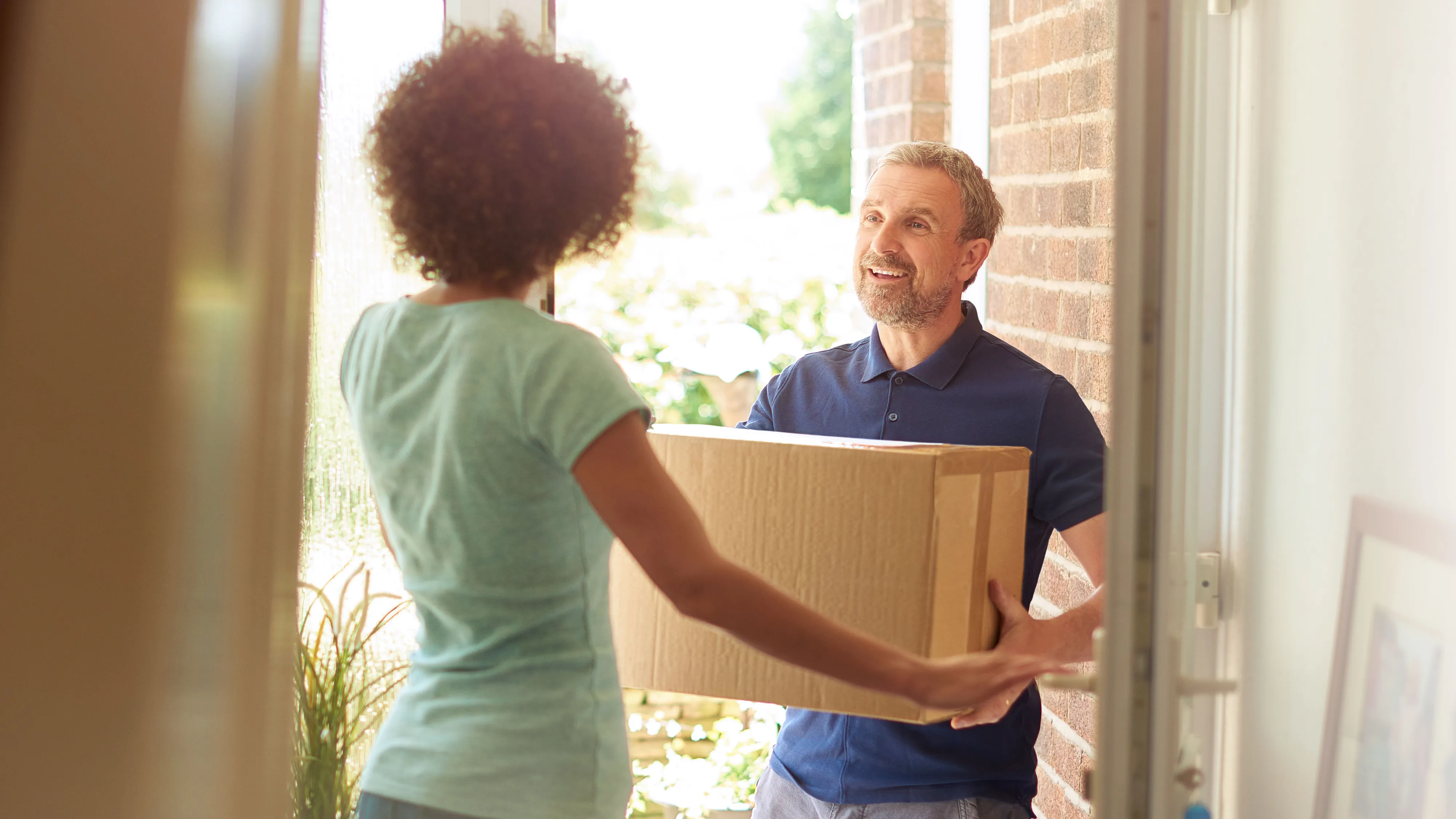 delivery man at the door and a woman opens