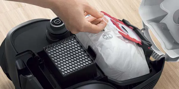 Opened vacuum cleaner showing a Bosch filter bag inside.