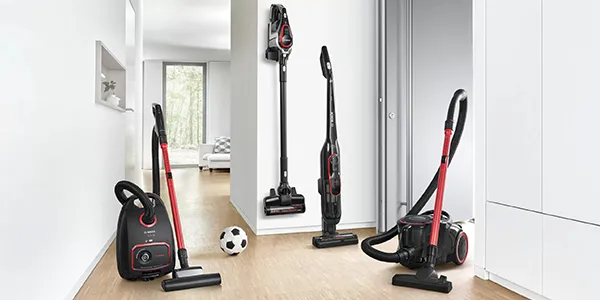 Three different types of vacuum cleaners displayed in a bright room.