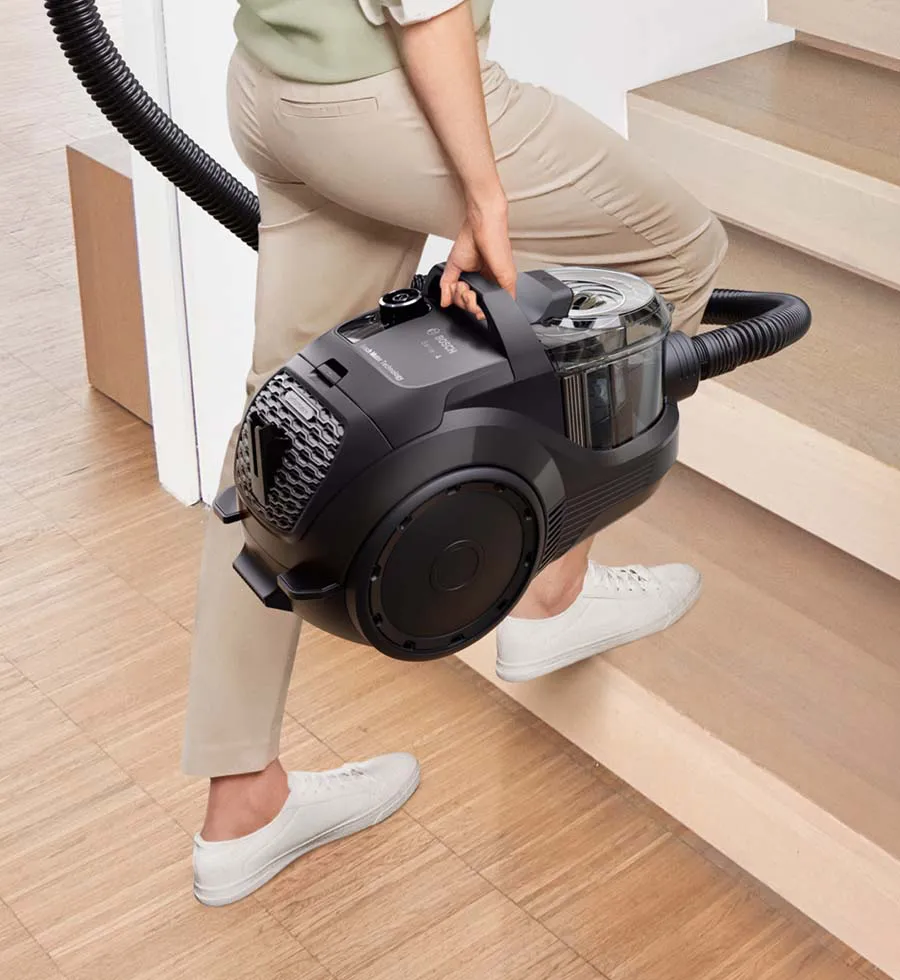 A bagged cylinder vacuum sucks up visible dirt on the floor.