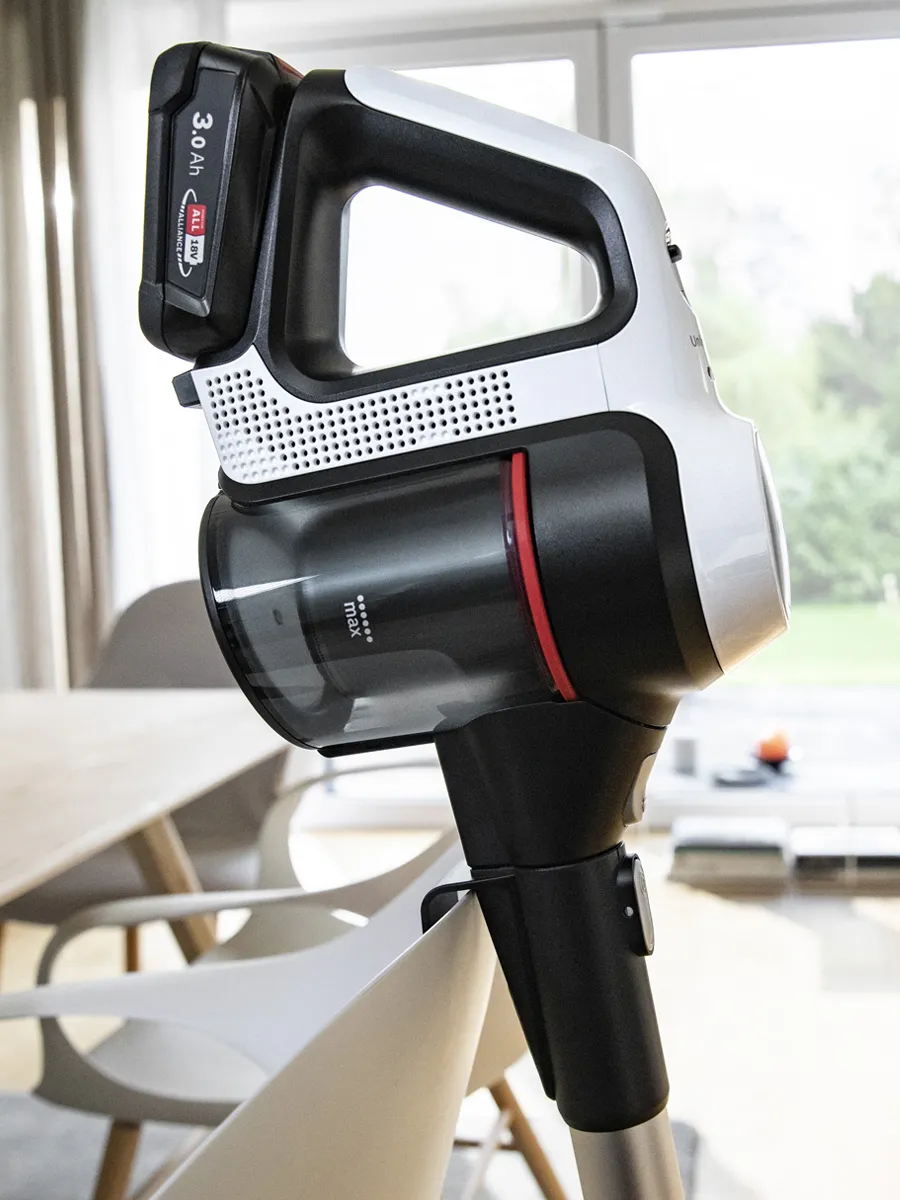 Bosch cordless vacuum cleaner with digital display, resting on a wooden surface.