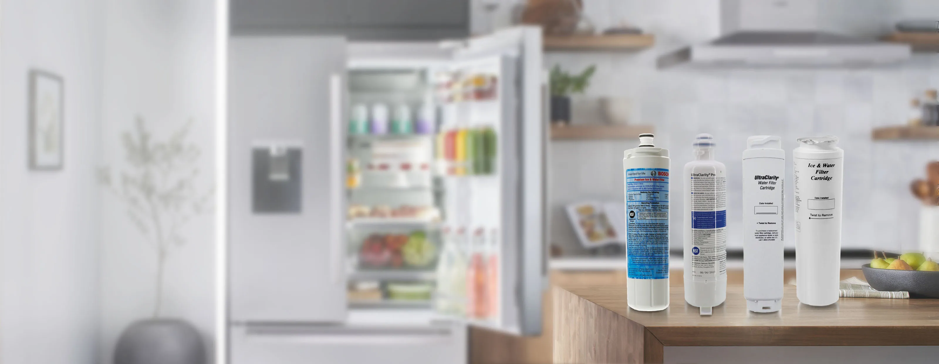 Bosch Water filter cartridges displayed on a kitchen counter with an open fridge in the background.