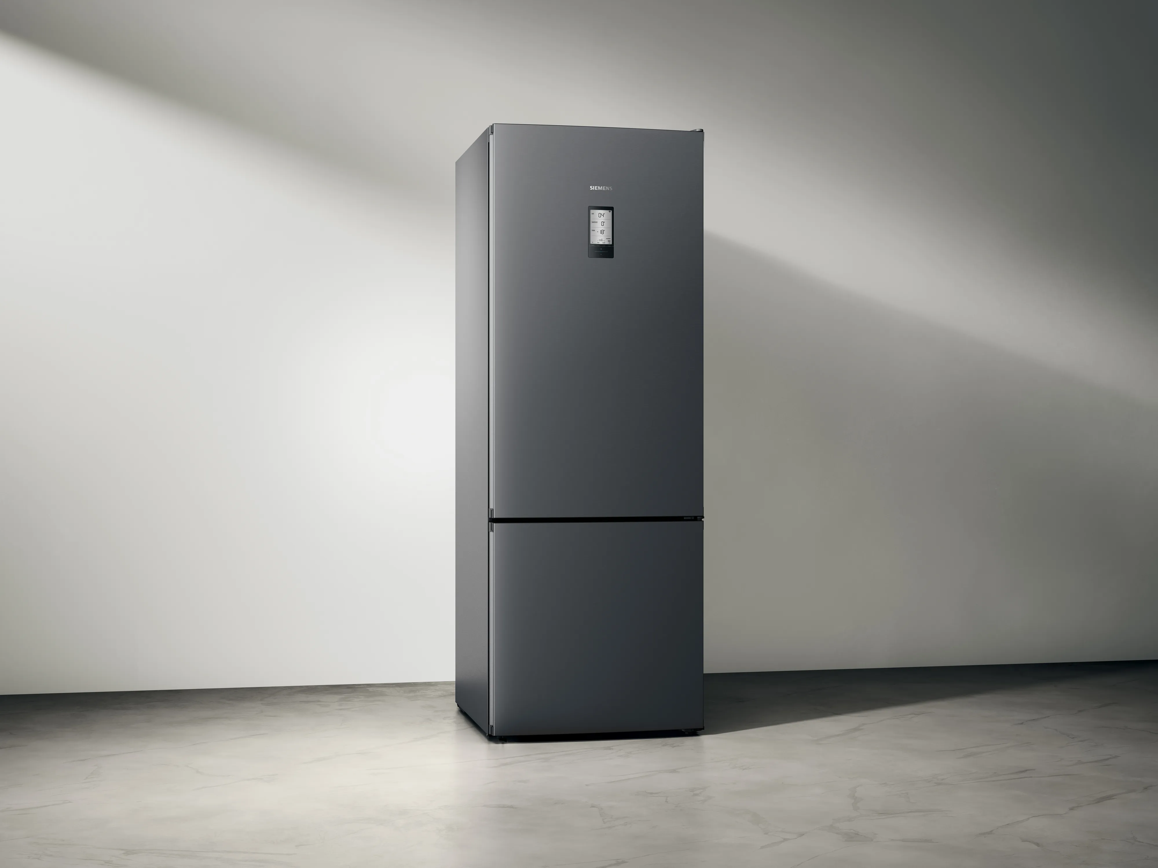 Modern black refrigerator in minimalist room.