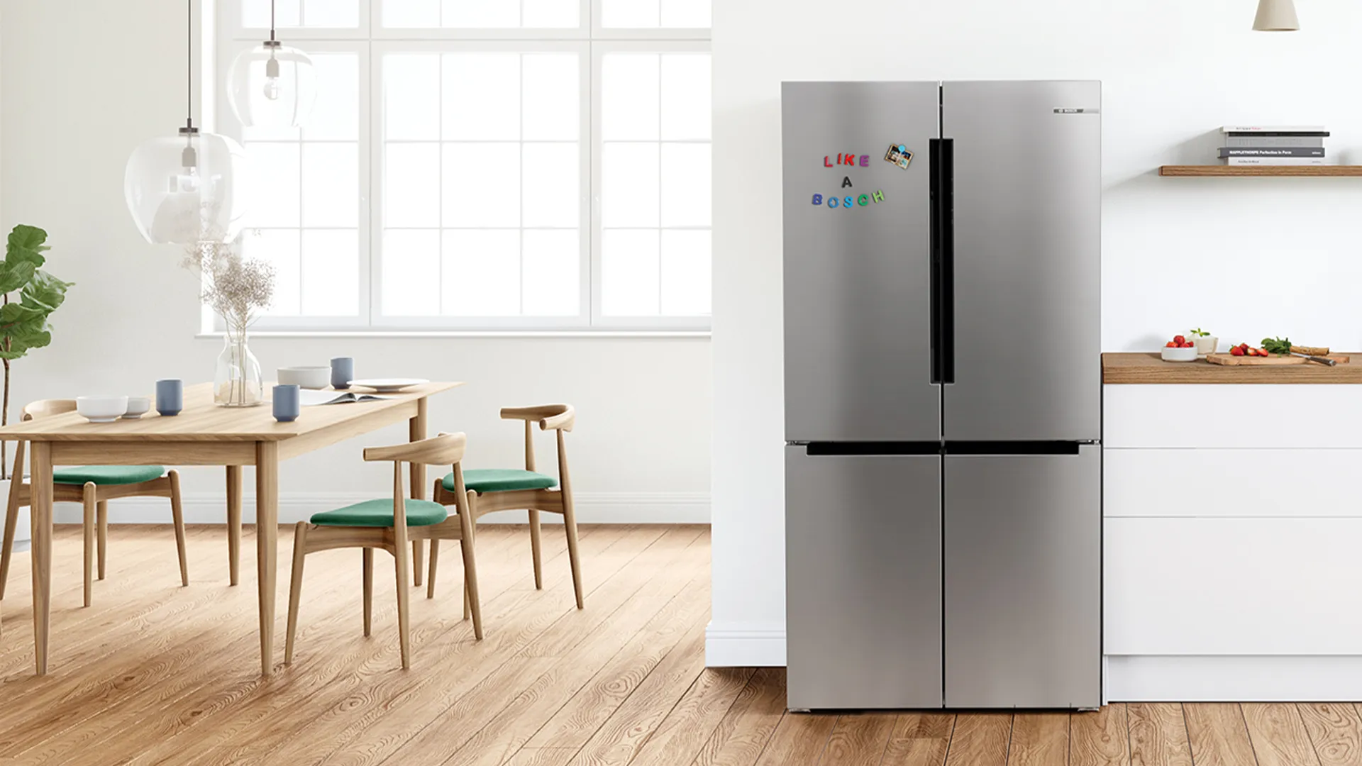 Modern kitchen with stainless steel refrigerator, gray cabinets, and minimalist decor.