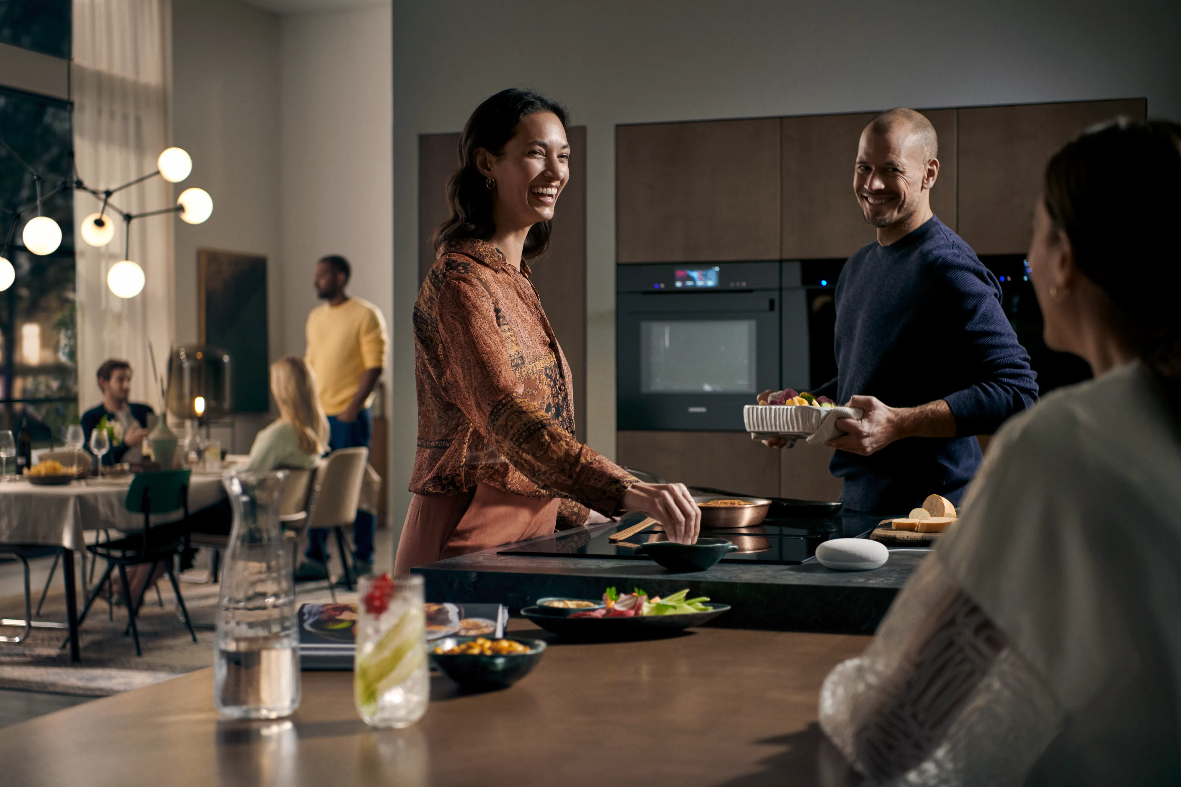 Cozinha moderna com armários pretos elegantes, refrigerador aberto e vários aparelhos de cozinha.
