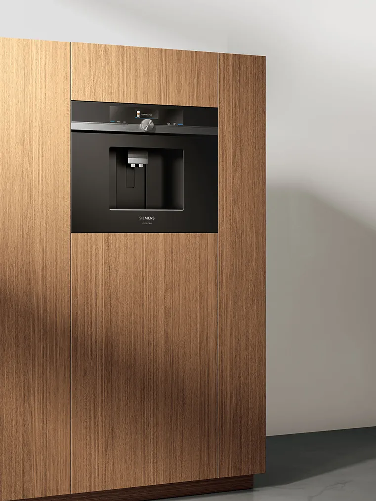 Built-in coffee machine, sleek black and silver design, modern kitchen appliance.