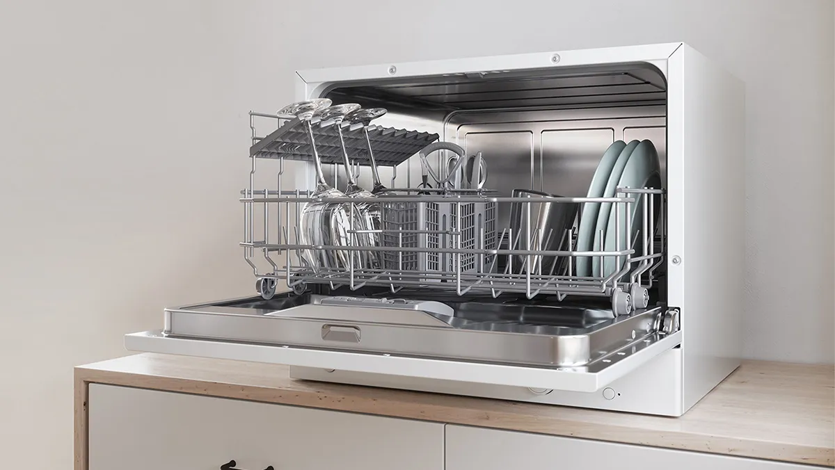 A modern kitchen corner featuring a Bosch dishwasher, minimalist sink, and a cookbook.