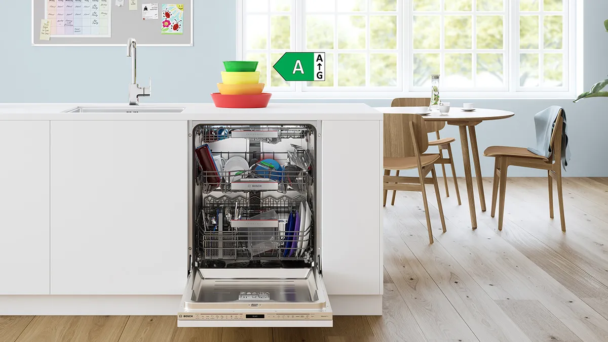 Modern kitchen with open dishwasher, colorful bowls, and dining table in natural light. A rated energy label