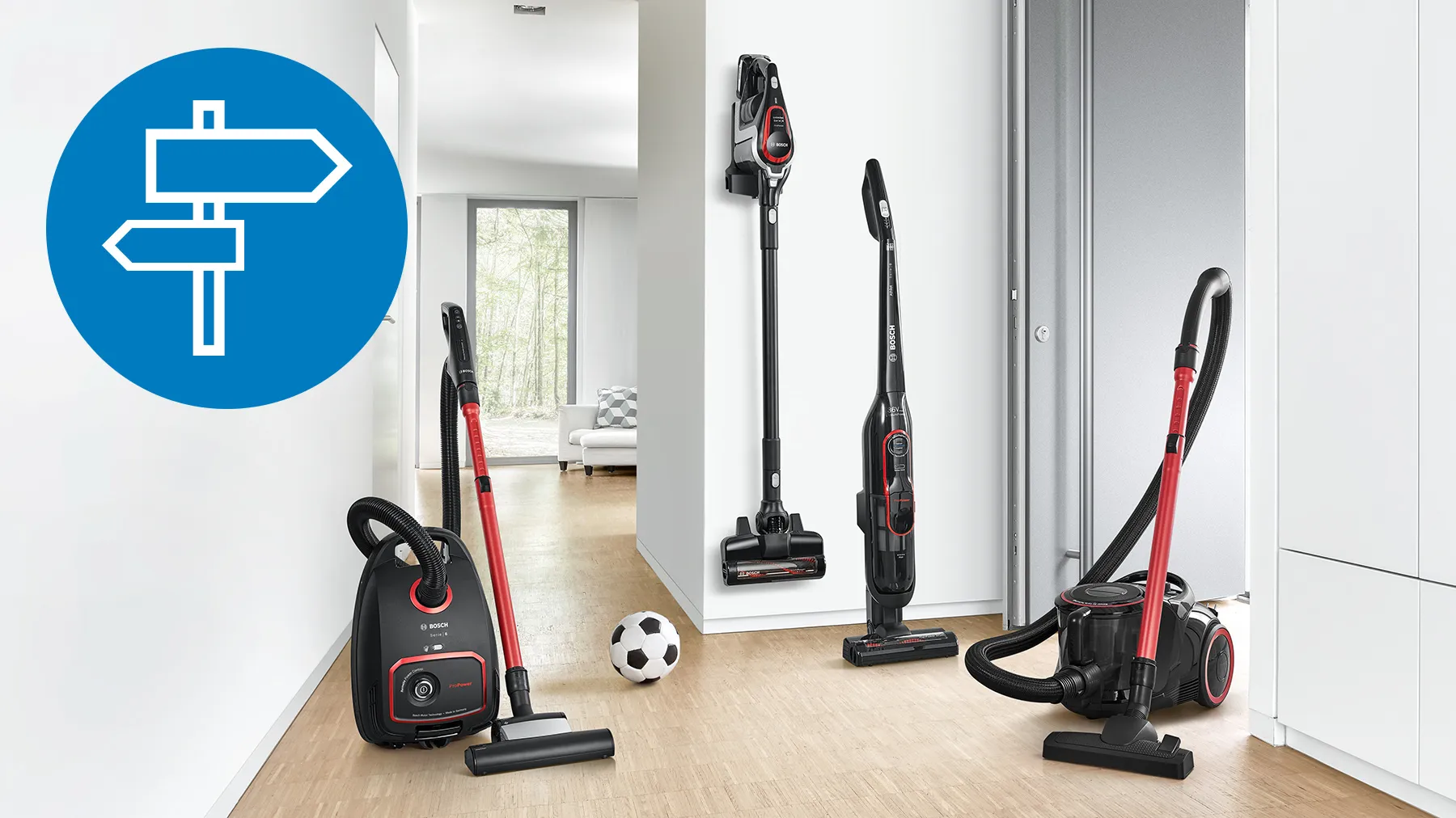 A modern hallway featuring various vacuum cleaners alongside a soccer ball on the floor.