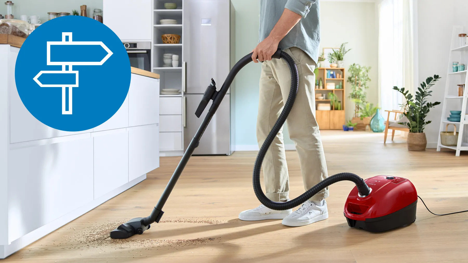 A modern hallway featuring various vacuum cleaners alongside a soccer ball on the floor.