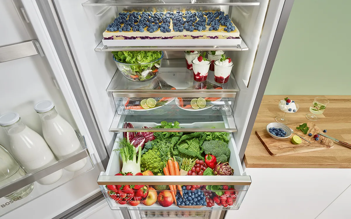 Réfrigérateur rempli de produits frais, laitiers et autres aliments sains.