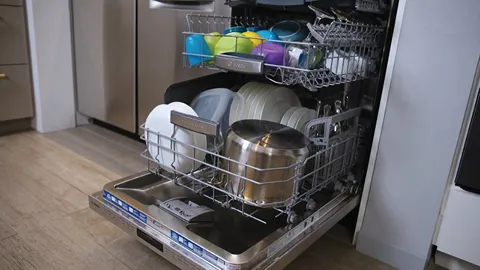 Open Bosch dishwasher with clean dishes, pots, and utensils inside.