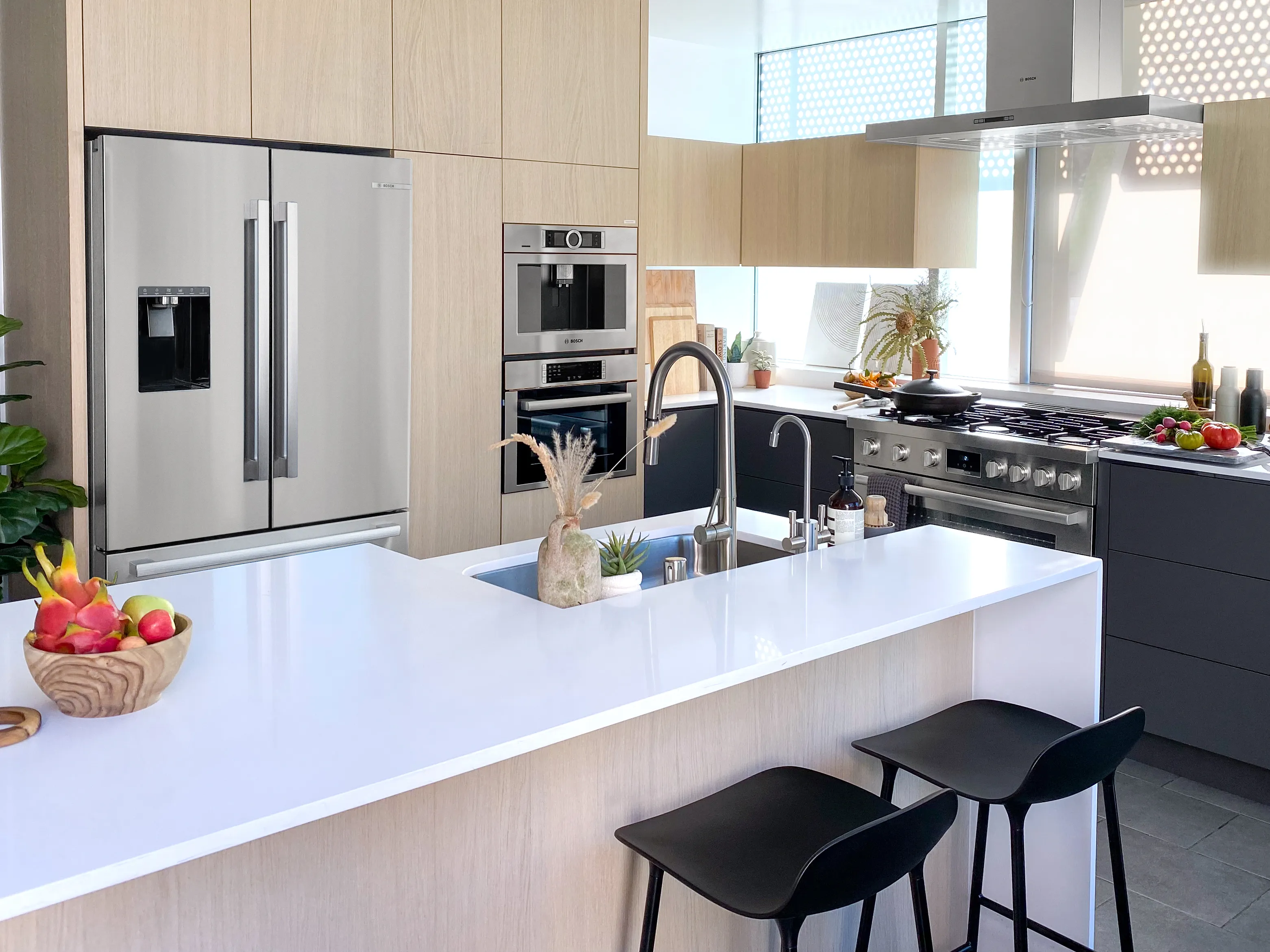 Modern kitchen with Bosch stainless steel appliances, island, and bar stools.