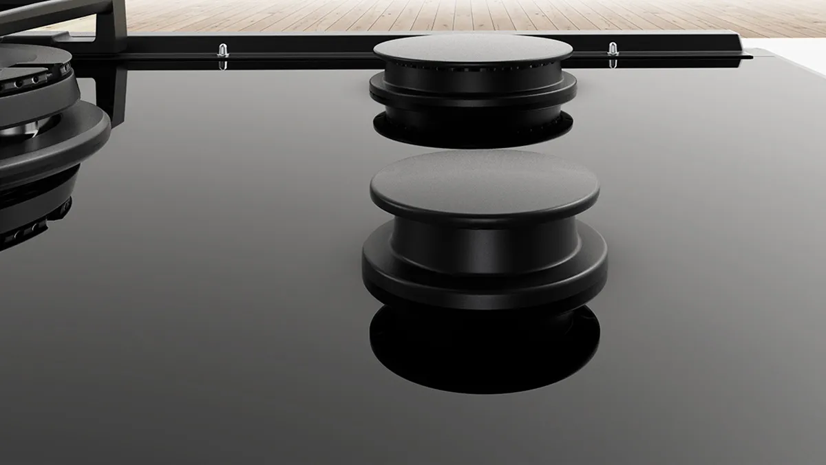 Černobílé audio zařízení s kruhovými knoflíky a reflexním povrchem.