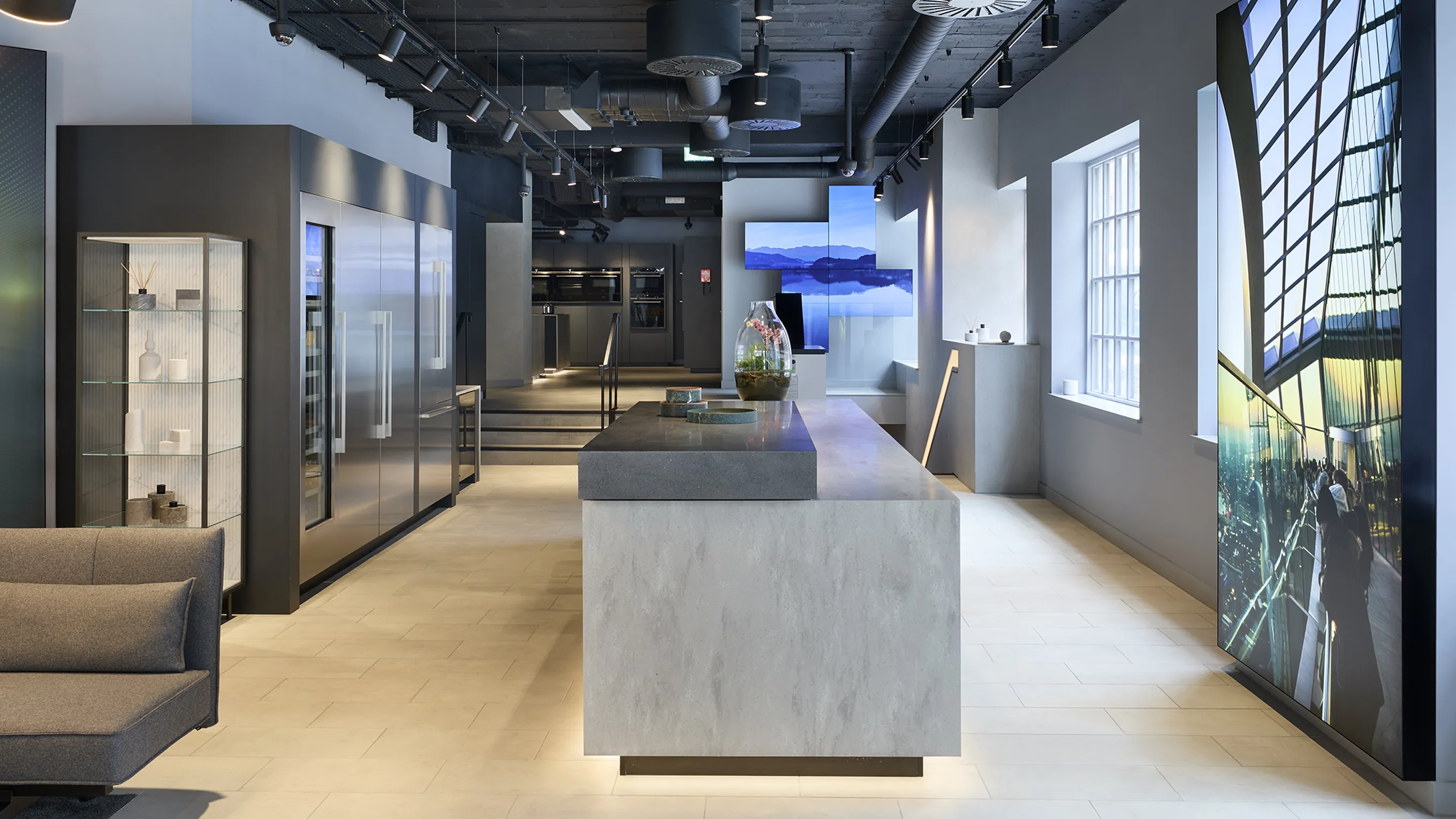 Modern office space with sleek furniture, large windows, and digital displays.