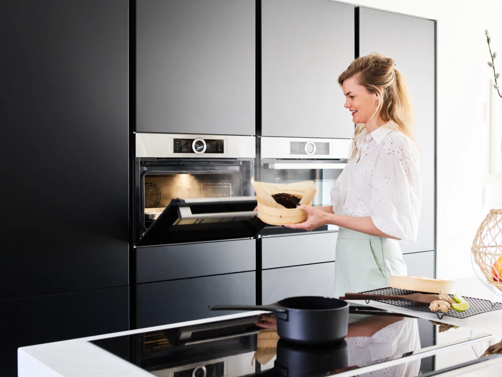 Femme en cuisine avec four, préparation de la nourriture, appareils de cuisine modernes.