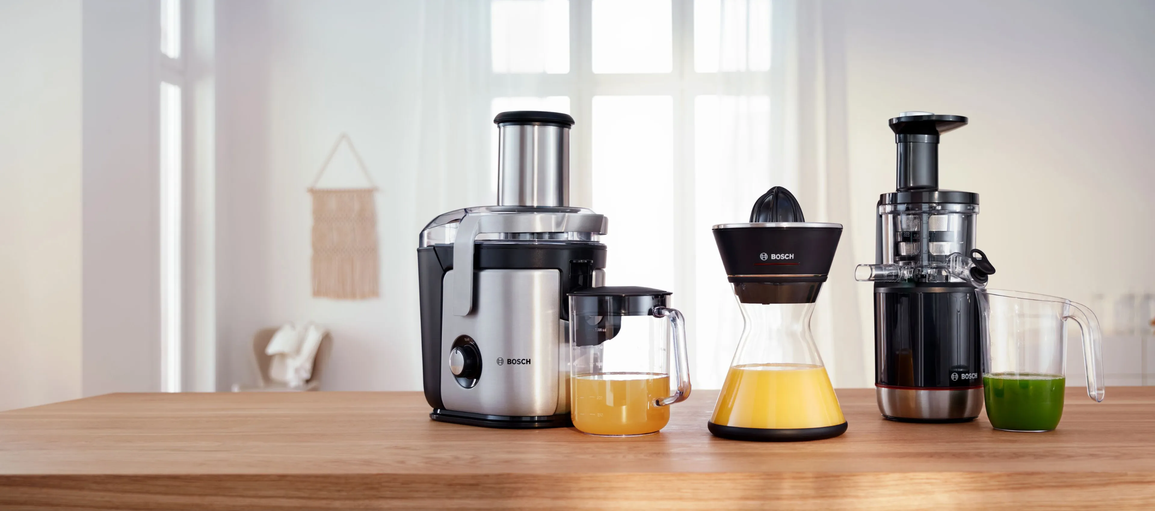 Line up of two Bosch juicers on a kitchen worktop.