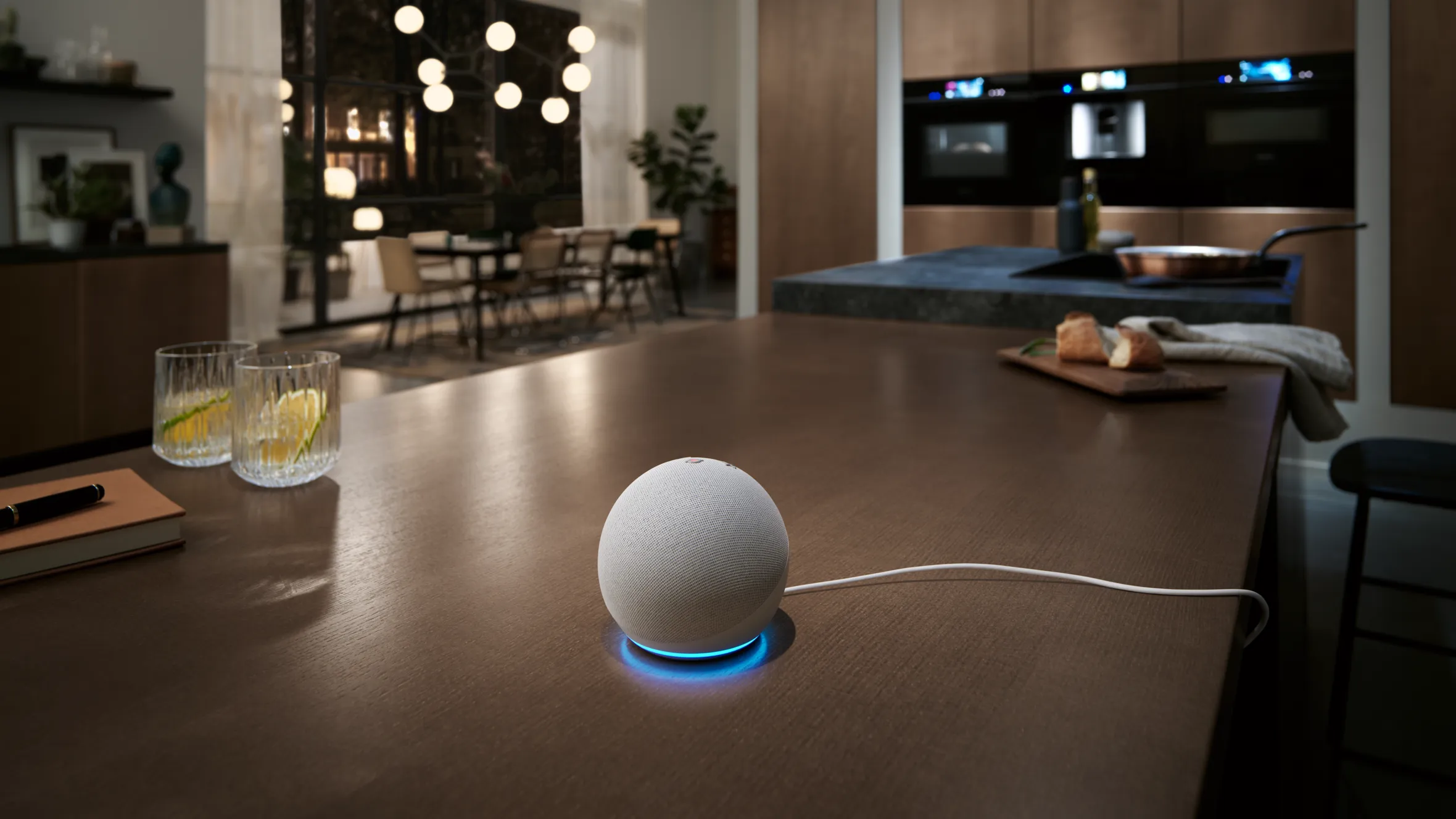 Sleek, modern kitchen with a white smart speaker on a wooden table.