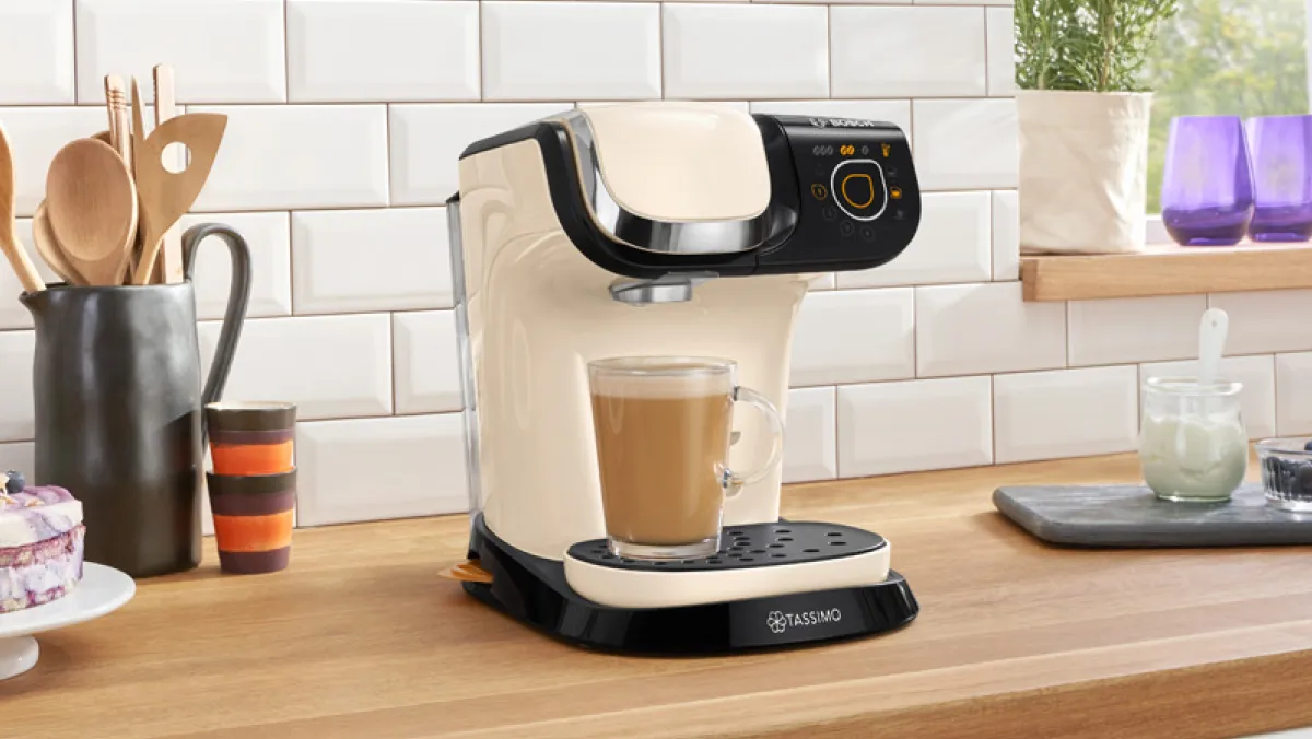Countertop with coffee maker, utensils, and decor items in a modern kitchen setting.
