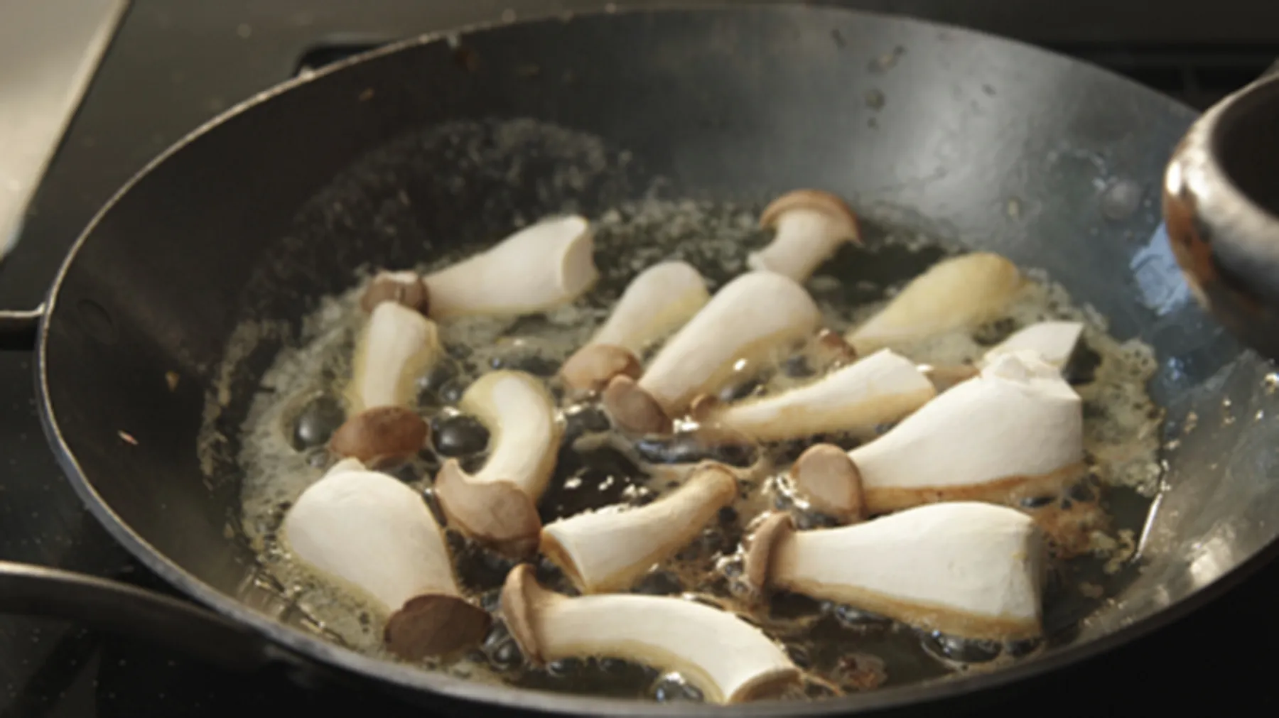 Sautéed mushrooms and onions in a cast iron skillet on a stovetop.