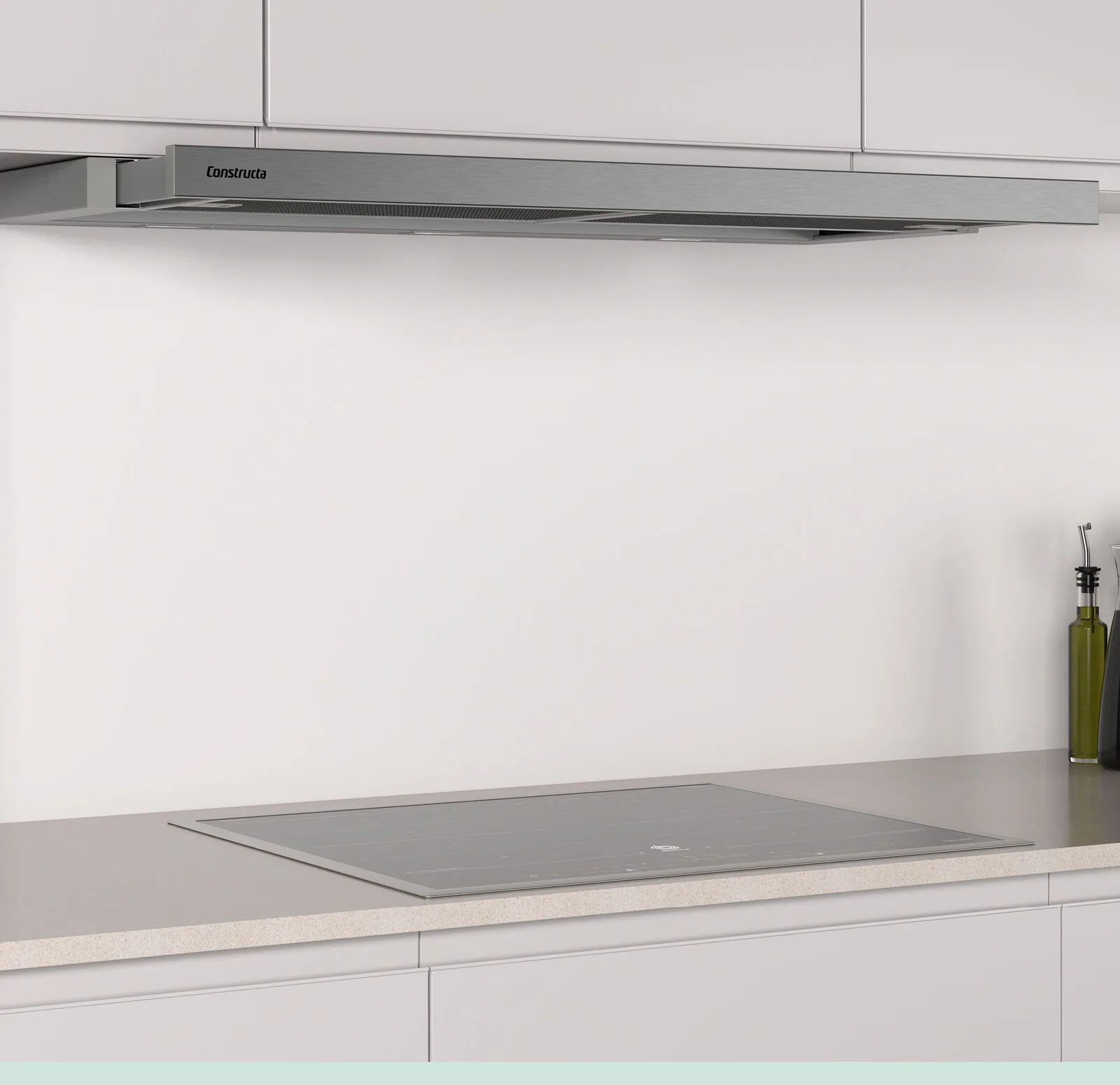 Eine schlanke, edelstahlfarbene Dunstabzugshaube von Constructa ist über einem Kochfeld in einer modernen, hellen Küche angebracht.