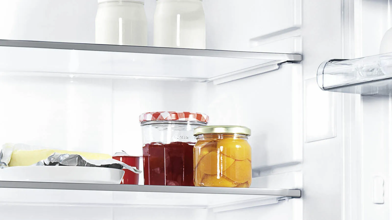 Regal in einem Constructa Kühlschrank mit Marmelade und Butter.