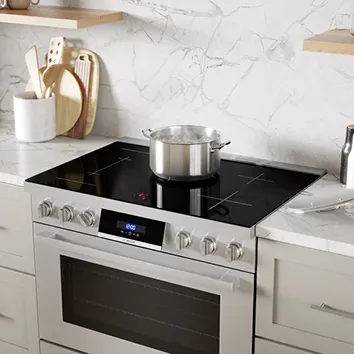 Modern kitchen with Bosch stainless steel range, induction cooktop, and pot on counter.